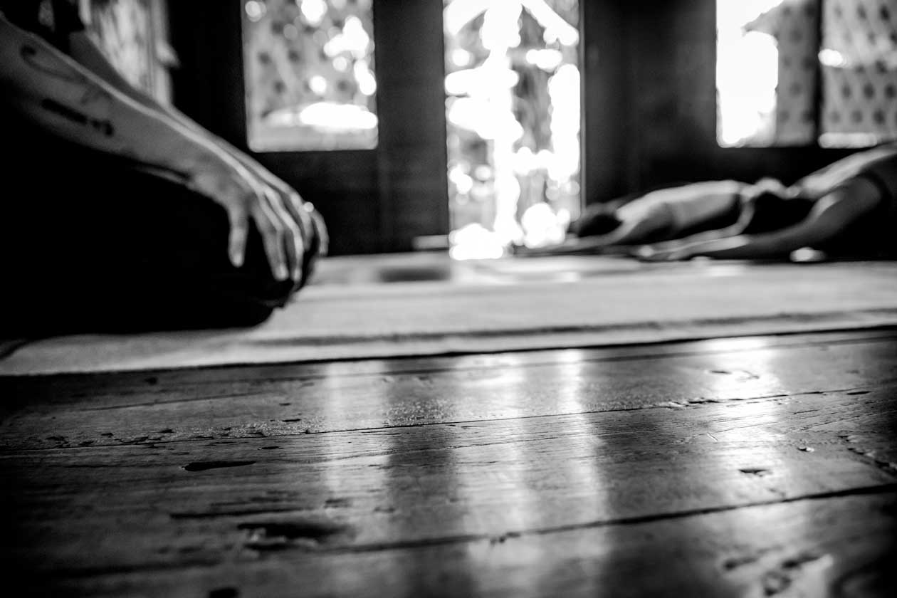 Yoga students at the end of an evening vinyasa yoga class in childs pose at Wild Rose Yoga Studio Chiang Mai, Thailand.